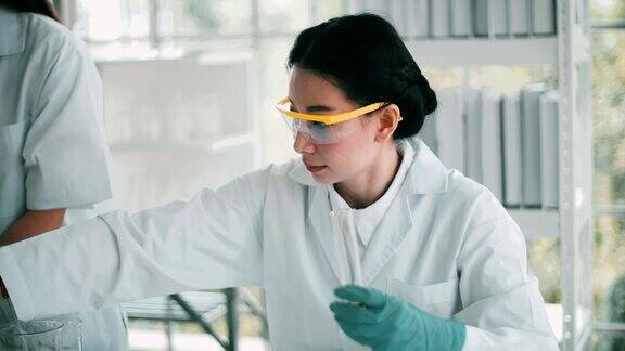 在实验室里使用吸管的女科学家