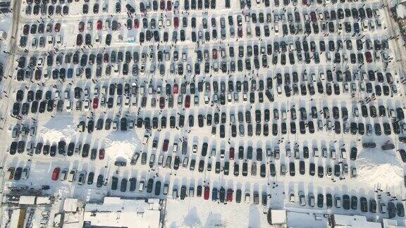 鸟瞰图冬季汽车市场或停车场上停放着许多待售的汽车和行人
