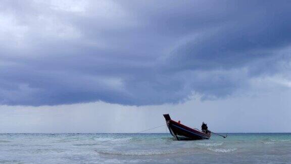 在浅海中长尾船在海滩附近摆动背景是泰国的风暴云