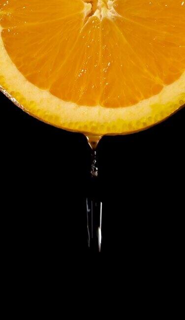 垂直和实时:水滴从橙色切片上的黑色