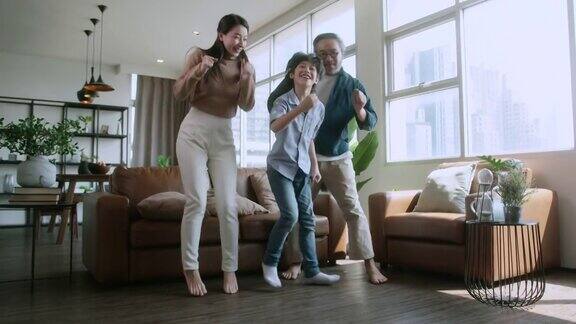幸福亚洲家庭在家中客厅一起跳舞亚洲爸爸妈妈和儿子移动锻炼身体周末早上在家隔离期间封锁期间