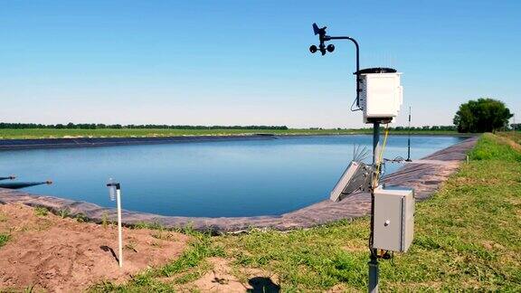 气象仪器农田里的一个小气象站在灌溉渠附近智能农业技术