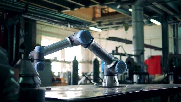 一个机器人在工厂的桌子上带着齿轮工作