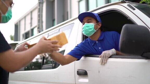 冠状病毒亚洲蓝色快递员戴着防护面具和医用橡胶手套在货车上给客户送包裹4k分辨率和慢动作拍摄