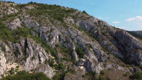 鸟瞰图在山的一侧绕着岩石飞行