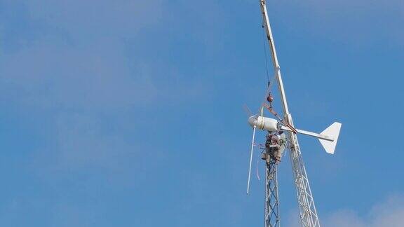 工人们正在修理风力涡轮机在蓝天的背景下那张脸难以辨认