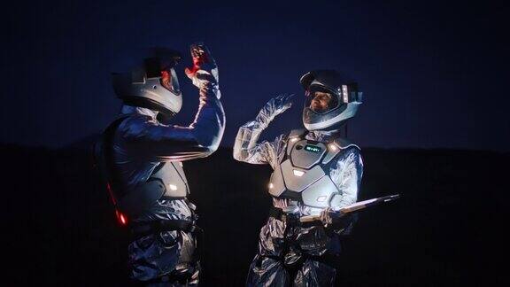 宇航员穿着未来主义服装带着发光的平板电脑在新星球上寻找路线