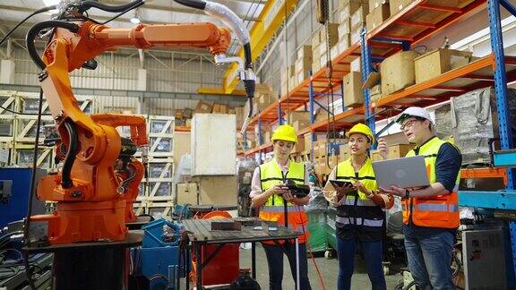一群亚洲男女工程师在建筑工地使用机械臂一起工作