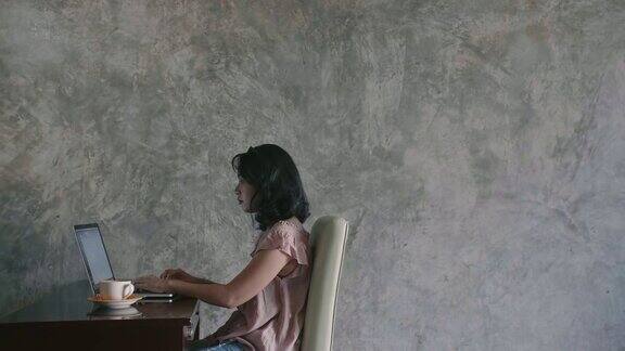 年轻女子坐在客厅里用笔记本电脑