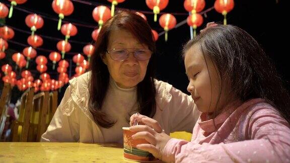 祖母和孙子在曼谷的夜市吃冰淇淋