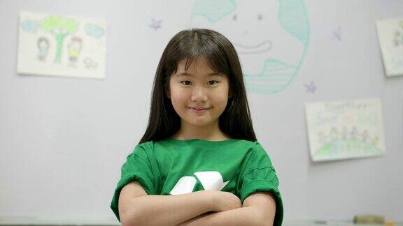 自信的亚洲小女孩穿着绿色生态t恤在教室里志愿、自然、教育理念