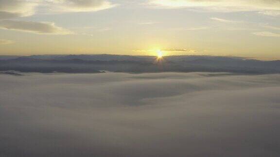 从空中俯瞰早晨从山上升起的太阳美丽的云