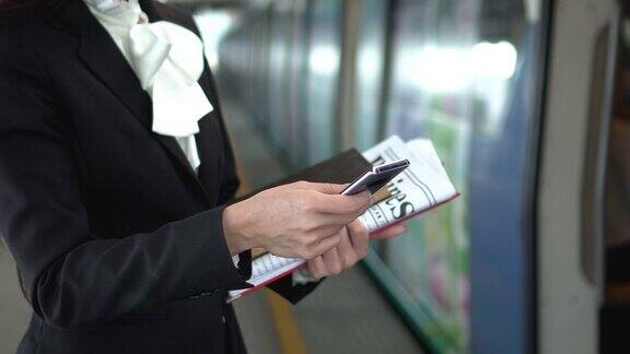 女商人站在站台上使用手机