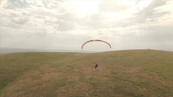 一个运动员骑着他的滑翔伞在燕子旁边飞行无人机后续拍摄
