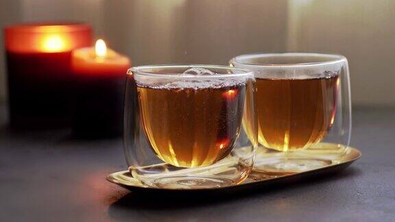 将带蒸汽的热红茶从玻璃壶中倒入透明的双层玻璃杯中