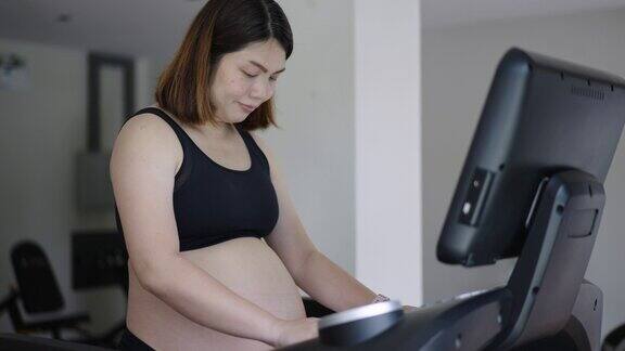 孕妇在健身房里在跑步机上行走锻炼身体和心脏健康