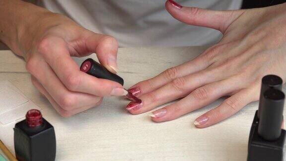 女孩给自己涂红色指甲油自己修指甲
