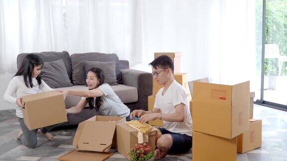 快乐的亚洲家庭搬到新房子用纸箱和整理房子