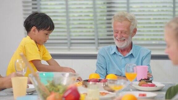 爷爷和孙子在餐桌上玩在午餐时玩得很开心