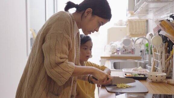 母亲和男孩在家厨房做饭