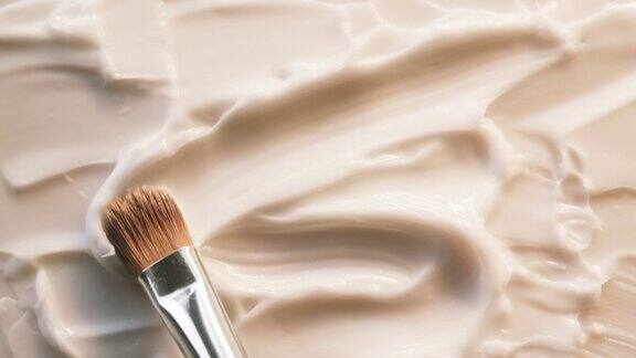 在白色背景上涂抹奶油使用笔刷润肤霜质地特写化妆品和美容产品概念化妆品