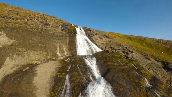 FPV航拍的大格里莫瀑布在冰岛风景优美的风景中向上飞行