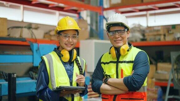 两名不同的专业重工业工程师穿着安全制服和安全帽工作