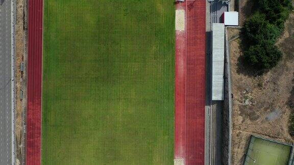 空旷的绿色橄榄球足球场和网球场俯视图