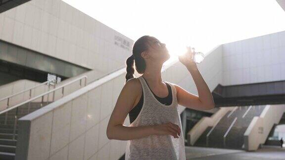 年轻女子运动后喝水休息