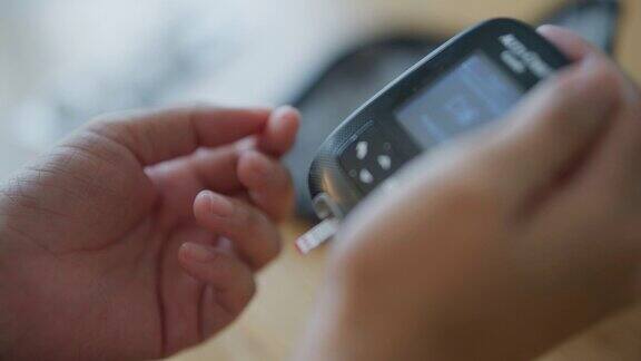 一位亚洲妇女在房间里用血糖测试来检查她的血糖