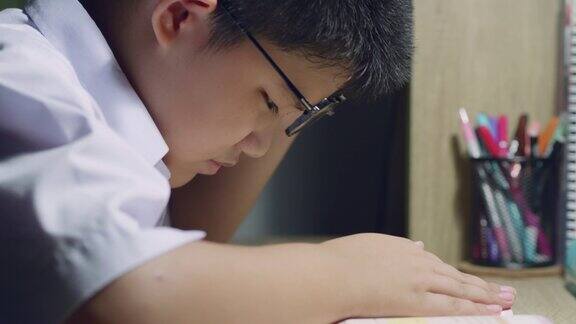 亚洲男孩校服戴眼镜看书近视症状