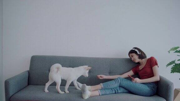 一个亚洲女人在客厅里和一只狗玩