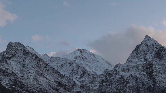 在印度喜马偕尔邦的拉豪尔在白雪覆盖的喜马拉雅山脉上空移动的云的4K时间间隔在冬天的山上傍晚日落时天空会消失自然与环境