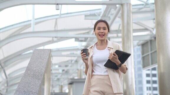 商务往返东南亚商业女性使用耳机与智能设备的背景建筑城市城市