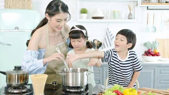 快乐的亚洲家庭在家里的厨房里一起做饭一起享受家庭活动