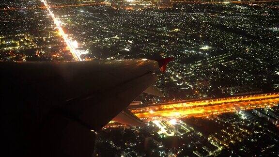 4K起飞夜航飞机机翼和城市从乘客座位窗口拍摄