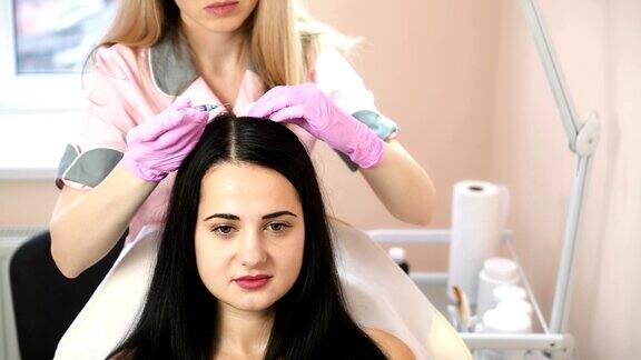英俊的女人被打了一针中间疗法推动以加强头发和它们的生长美容师的工作