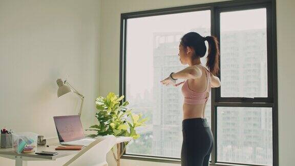 亚裔女性在公寓里在线直播瑜伽课