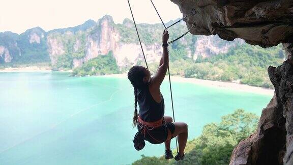 4K亚洲女人在夏天攀登热带岛屿的岩石山