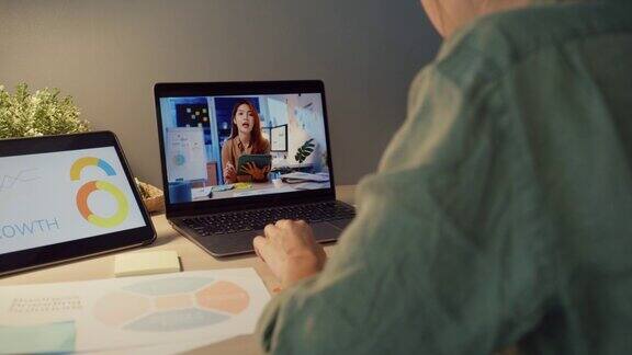 亚洲女商人在家里的客厅用笔记本电脑与同事视频通话讨论计划