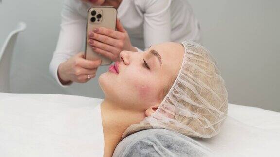医务室里一名女医生在给病人注射透明质酸、面部矫正和美容后用手机给病人拍照