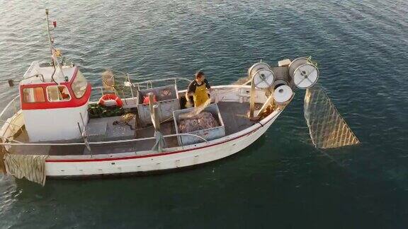 中年成年渔夫在用拖网捕鱼