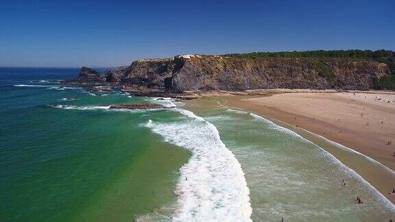 葡萄牙奥德赛阿连特茹村附近的海湾和海滩的无人机航拍视频游客在水里冲浪背景是岩石
