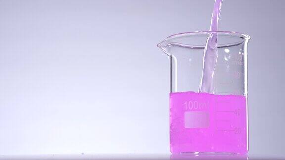 在烧杯中倒入粉红色的液体溶液