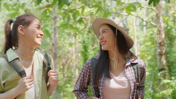 亚洲美丽的两个女人背包旅行在森林野生一起迷人的年轻女性朋友们在夏天的假期旅行期间散步和探索自然树林的快乐