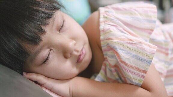可爱的亚洲小女孩睡在沙发上