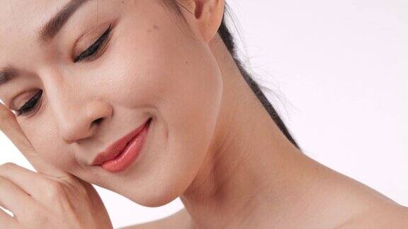 美丽的年轻亚洲女人触摸脸和健康的皮肤的特写