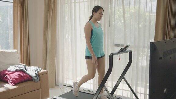 女人在跑步机上跑步在家健身房锻炼