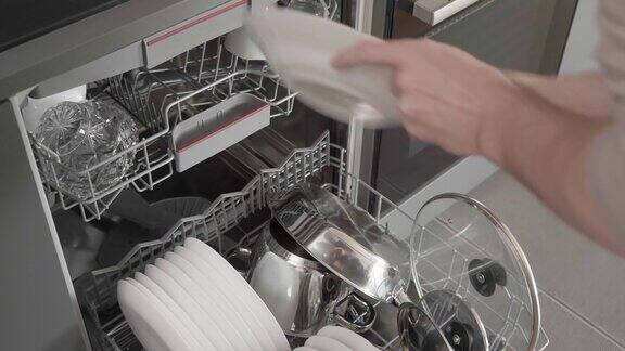 这个人把脏盘子放进洗碗机开始洗碗