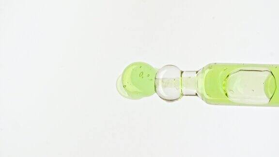 移液管与透明绿色化妆品凝胶液血清与分子气泡油在白色背景天然有机化妆品医药的宏观镜头生产特写慢动作